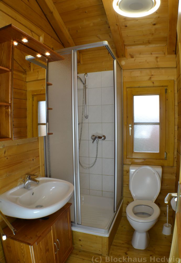 Duschbad im Blockhaus mit Spiegelschrank, Waschtisch, WC, Dusche, Fn, Kindertritt und Sitzverkleinerer