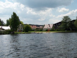 Blick auf den Badebereich mit Sandstrand, Bootsverleih und kleinem Spielplatz am Neubuer See