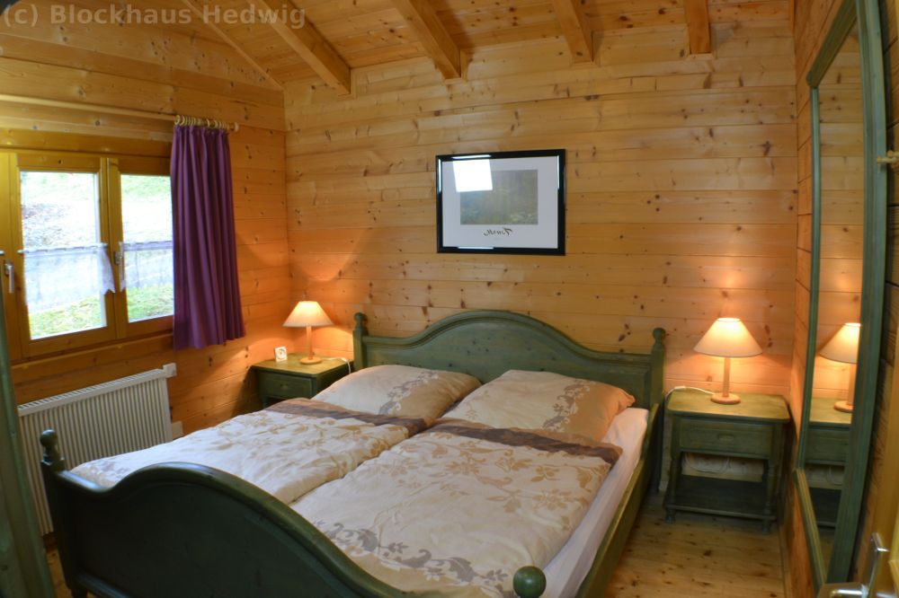 1. Schlafzimmer mit Doppelbett, Spiegel, Nachttische und Wecker.